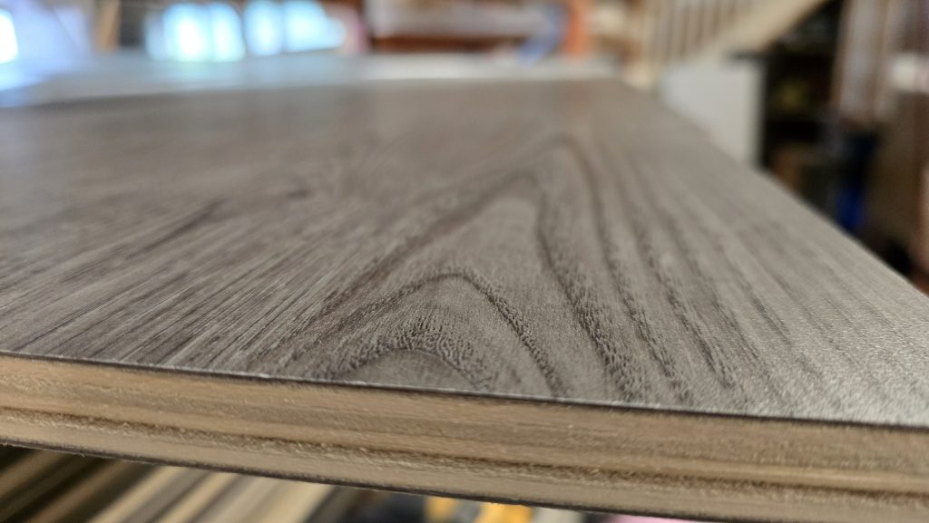 Grey woodgrain laminate surface, close up