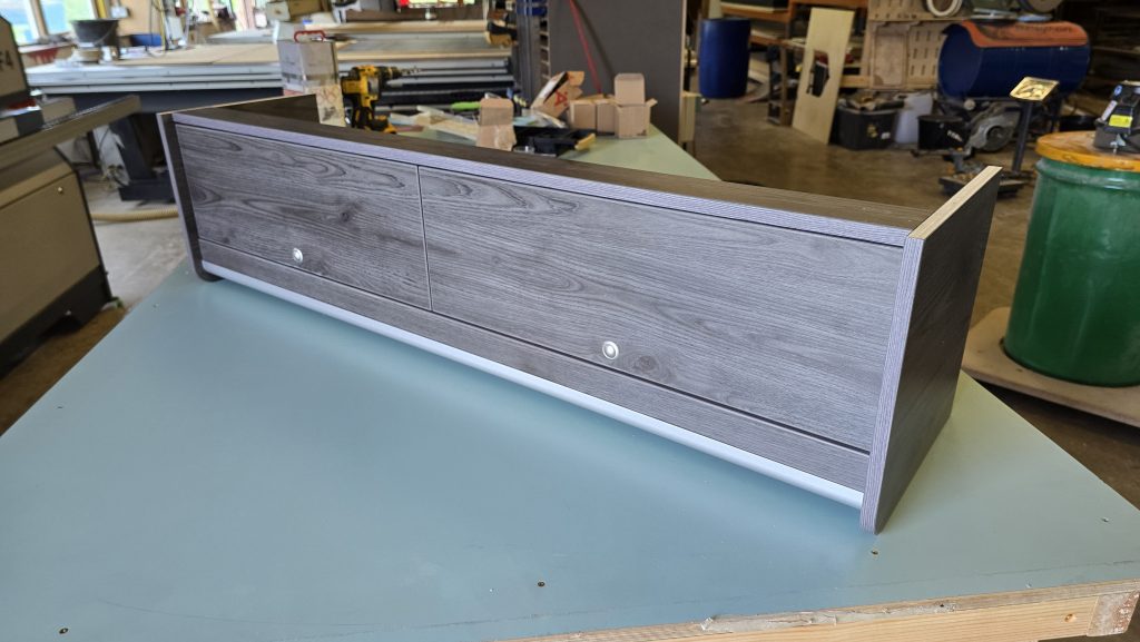 Campervan overhead locker in grey woodgrain laminate with doors fitted